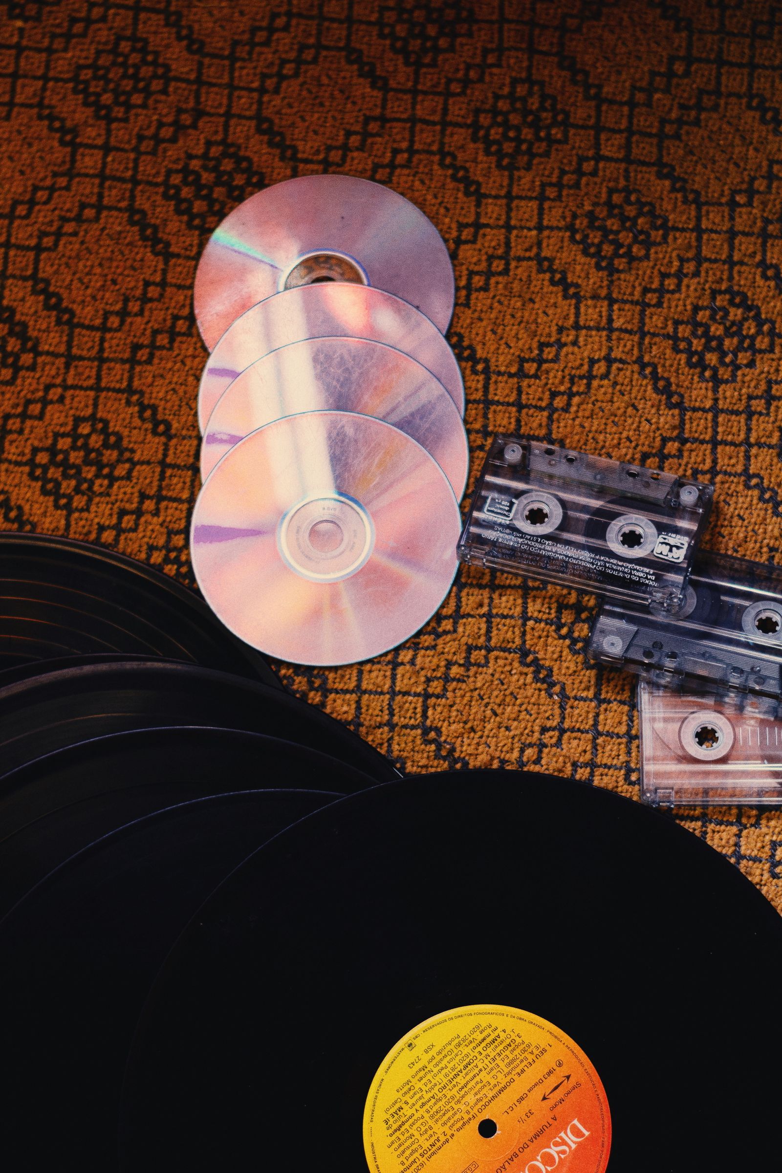 Une collection de CD, disques vinyles et cassettes audio, symbole des médias physiques à numériser